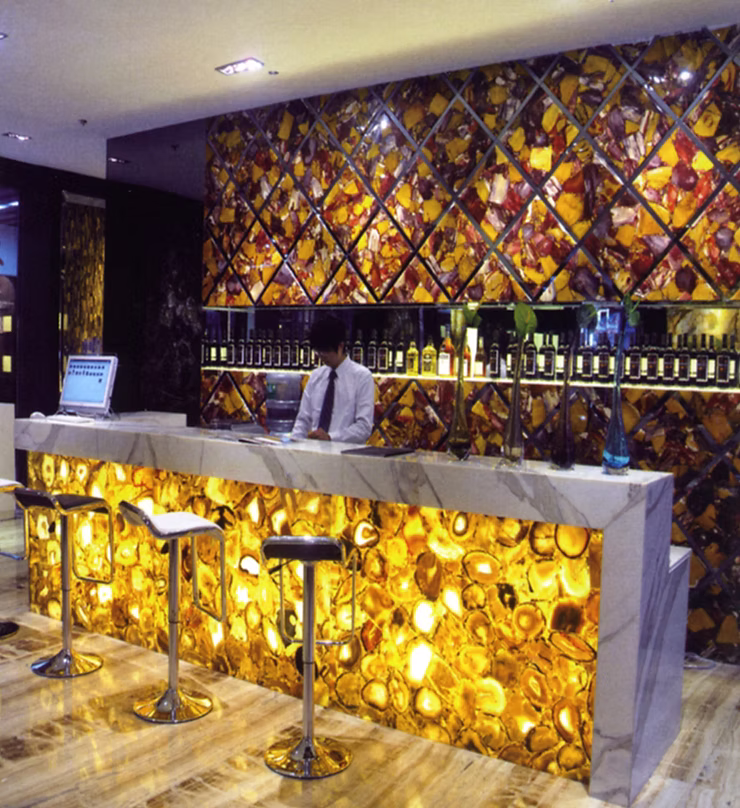 Подсвечиваемая барная стойка из дымчатого кварцита с мягким золотистым свечением.