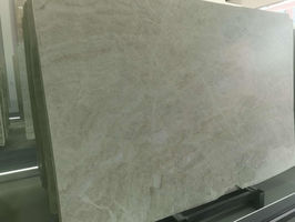Polished Taj Mahal quartzite natural stone slab displayed upright in a stone warehouse
