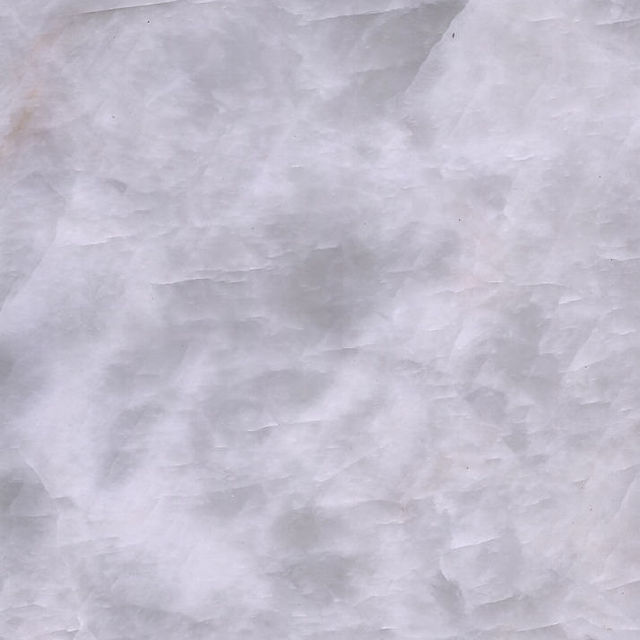 When choosing between natural White Onyx and White Quartz for interior design, understanding their distinct characteristics is crucial. While both offer elegance and versatility, they differ in composition, durability, and maintenance.    Onyx consists of large, solid slabs that are meticulously processed to create unique and large panels. Quartz, on the other hand, is more commonly found in smaller sizes in nature. Each stone is individually processed: it is carefully cut, polished, and treated. Then, they are manually assembled into Duramica panels, filled with special compounds, and undergo technological treatments and polishing. Thanks to Duramica technology, quartz can be assembled into large panels, creating durable and striking products.    White Onyx: Translucent Luxury with a Delicate Touch  White Onyx is a natural stone admired for its translucent beauty and unique veining. Its ability to be backlit makes it a premium choice for feature walls, countertops, and decorative panels.
