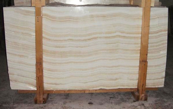 When choosing between natural White Onyx and White Quartz for interior design, understanding their distinct characteristics is crucial. While both offer elegance and versatility, they differ in composition, durability, and maintenance. Onyx consists of large, solid slabs that are meticulously processed to create unique and large panels. Quartz, on the other hand, is more commonly found in smaller sizes in nature. Each stone is individually processed: it is carefully cut, polished, and treated. Then, they are manually assembled into Duramica panels, filled with special compounds, and undergo technological treatments and polishing. Thanks to Duramica technology, quartz can be assembled into large panels, creating durable and striking products. White Onyx: Translucent Luxury with a Delicate Touch White Onyx is a natural stone admired for its translucent beauty and unique veining. Its ability to be backlit makes it a premium choice for feature walls, countertops, and decorative panels.