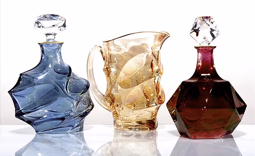 GRIFFE MONTENAPOLEONE VETRERIE DI EMPOLI Transparent wine carafe on a marble countertop in soft lighting.