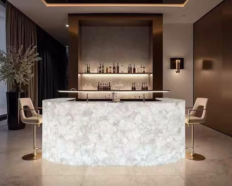 Интерьер бара с подсветкой — барная стойка из оникса и подсвечиваемая стена из кварцита.