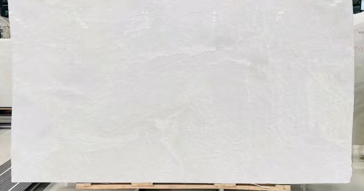 When choosing between natural White Onyx and White Quartz for interior design, understanding their distinct characteristics is crucial. While both offer elegance and versatility, they differ in composition, durability, and maintenance. Onyx consists of large, solid slabs that are meticulously processed to create unique and large panels. Quartz, on the other hand, is more commonly found in smaller sizes in nature. Each stone is individually processed: it is carefully cut, polished, and treated. Then, they are manually assembled into Duramica panels, filled with special compounds, and undergo technological treatments and polishing. Thanks to Duramica technology, quartz can be assembled into large panels, creating durable and striking products. White Onyx: Translucent Luxury with a Delicate Touch White Onyx is a natural stone admired for its translucent beauty and unique veining. Its ability to be backlit makes it a premium choice for feature walls, countertops, and decorative panels.
