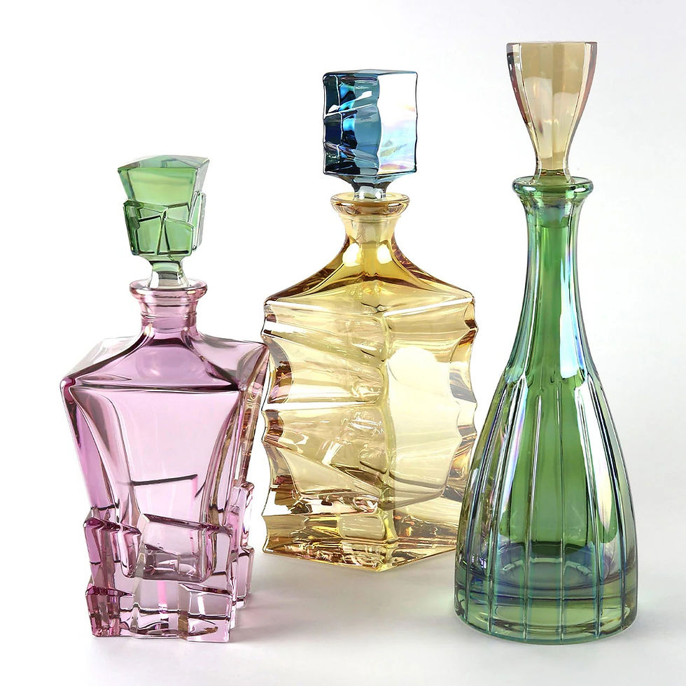 Miniatura: Handcrafted green crystal bottle standing tall with pink and amber crystal decanters on white