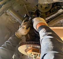 Hands working on car brake and suspension