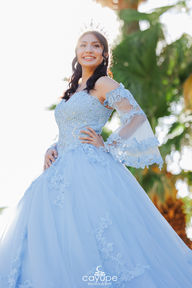 Dezeray posing in front of the lake at Agua Caliente Park, wearing a pastel blue dress with a natural background.