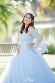 Dezeray with her hands on her waist under natural light, showcasing the lace details of her quinceañera dress.
