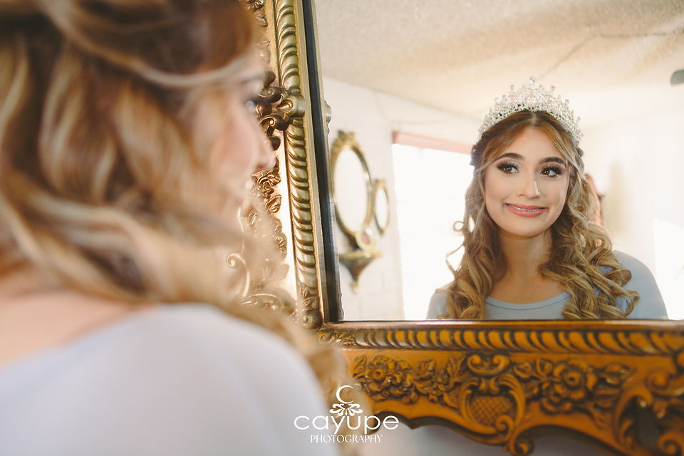 Close-up of Dezaray smiling at her reflection in a vintage mirror, wearing a tiara during the getting-ready moments—capturing personal touches in The Secret to Choosing the Perfect Venue..