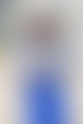 Young woman in a royal blue graduation gown holding her decorated cap with the words "Pretty, Educated, and Graduated."