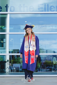 7. Graduation portrait of Cassandra in cap and gown in front of Eller College, beaming with pride during her senior photo session.
