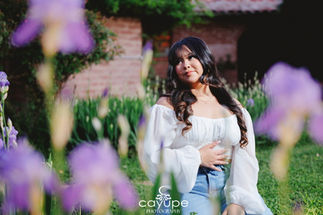 Dreamy photo of Jasmine sitting among blooming purple flowers, looking serene at Agua Linda Farm.