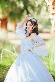 Dezeray with an elegant expression and her hands raised, highlighting the sparkling details of her dress.