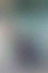 Joyful moment of Cassandra jumping in celebration with her graduation cap held high at McClelland Hall, Eller College.