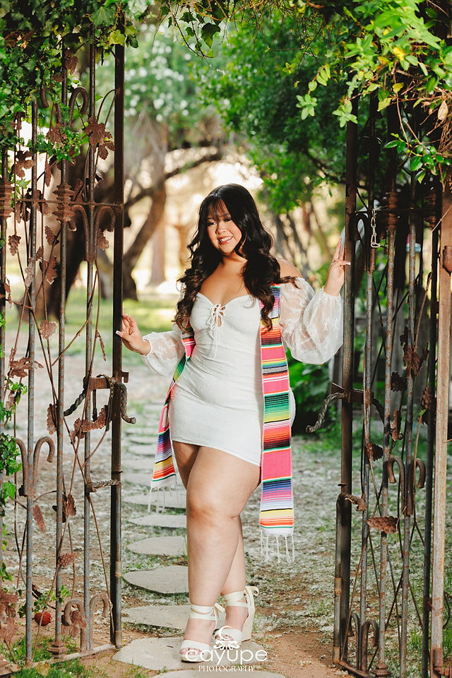 Jasmine smiling with confidence as she poses in a rustic archway at Agua Linda Farm