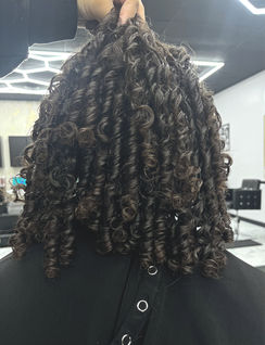 Person's back, dark coily hair styled in a salon in Greenville SC.