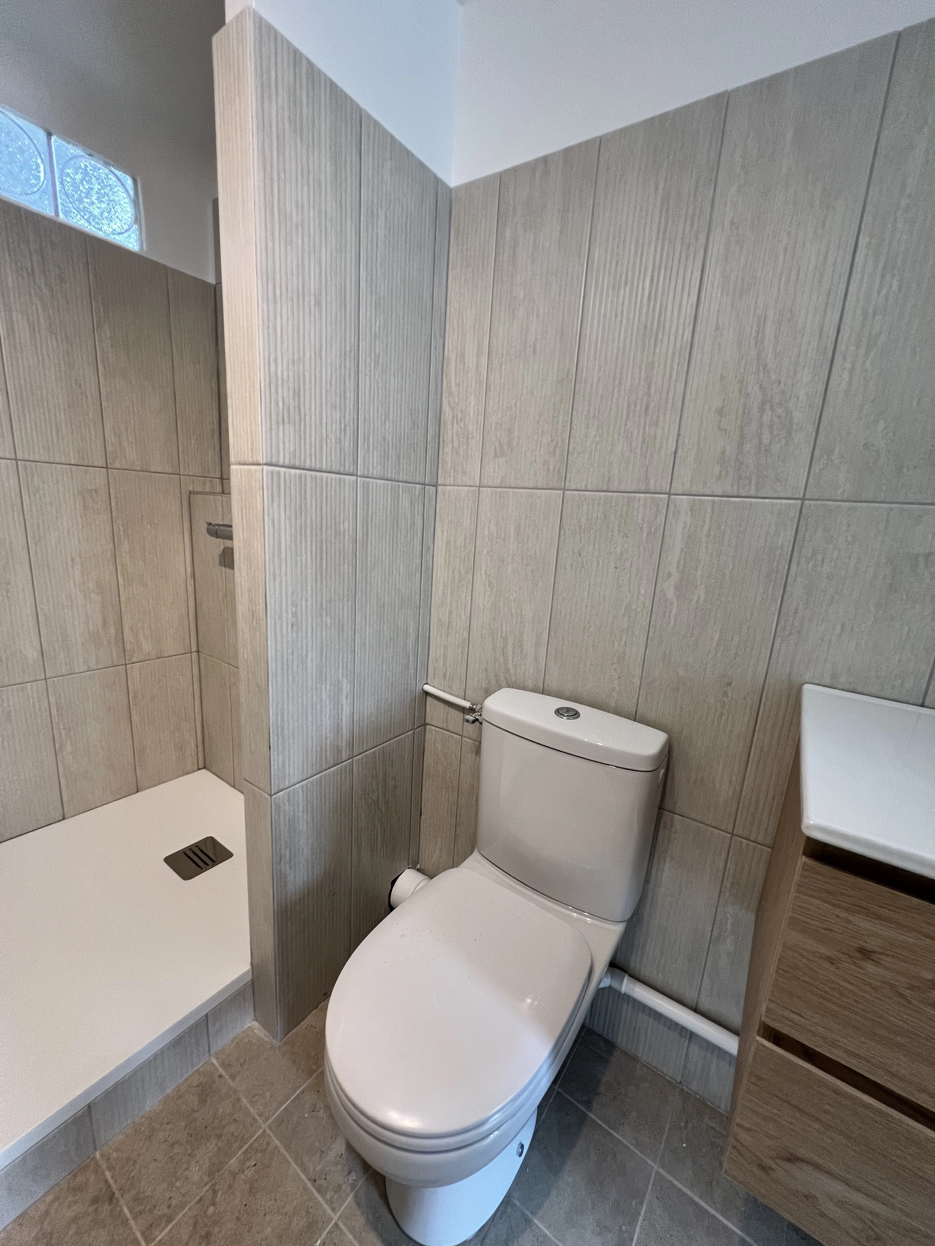 Carrelage imitation travertin et faïence texturée blanc cassé pour une finition élégante et moderne.