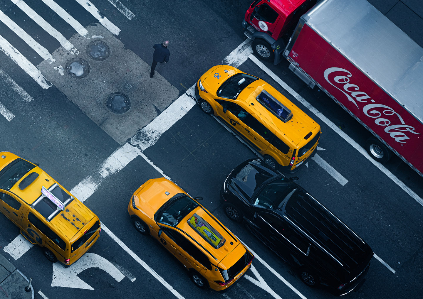 An overhead shot of 6th Avenue showing three cabs and a Soda Truck. 