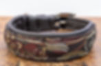 Schwarzes Lederhalsband. Besatz aus glänzendem, schwarzen Leder, mit rankenartigem Muster in rot, gelb und silber.