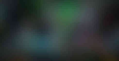 Multi-exposure image of artist and partner in dimly lit studio with brightly colored artworks