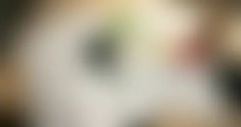 Pessoa organizando documentos de dívidas de vários bancos sobre mesa, com calculadora mostrando 30% do salário, representando repactuação de dívidas