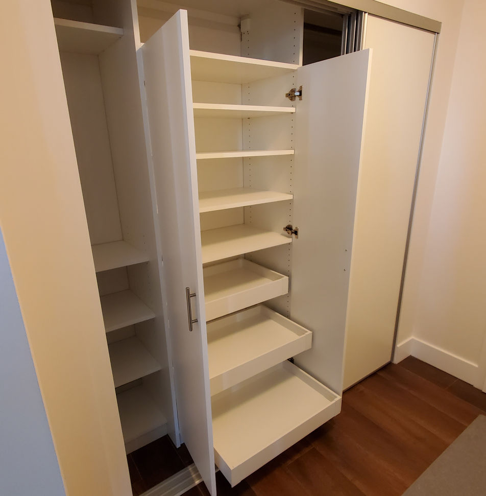 Pull-out vertical storage tower for shoes in deep closet.