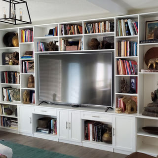 Large white built-in media center with bookshelves surrounding TV.