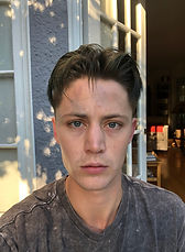 Young person with short dark hair and light eyes