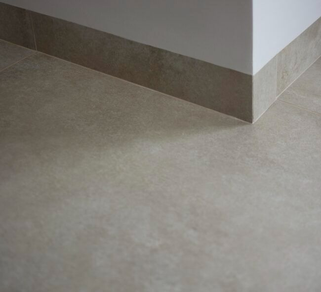 Ambientes ilustrando rodapés embutido, negativo, porcelanato, granito/mármore, PS/PVC, MDF, madeira maciça e metálico em diferentes estilos, com foco em acabamento, textura e integração com o piso e a parede.
