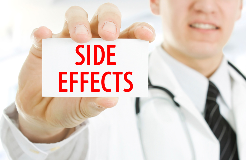 A doctor holding a card up close that says "side effects"