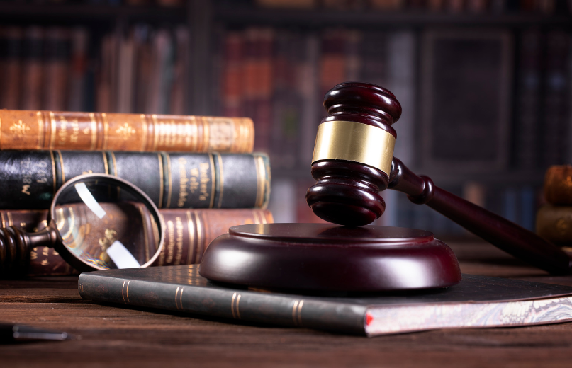 A picture of a judge's gavel and legal books on a desk