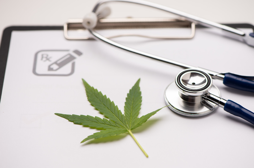 A prescription pad with a stethoscope and a marijuana leaf on top of a clipboard