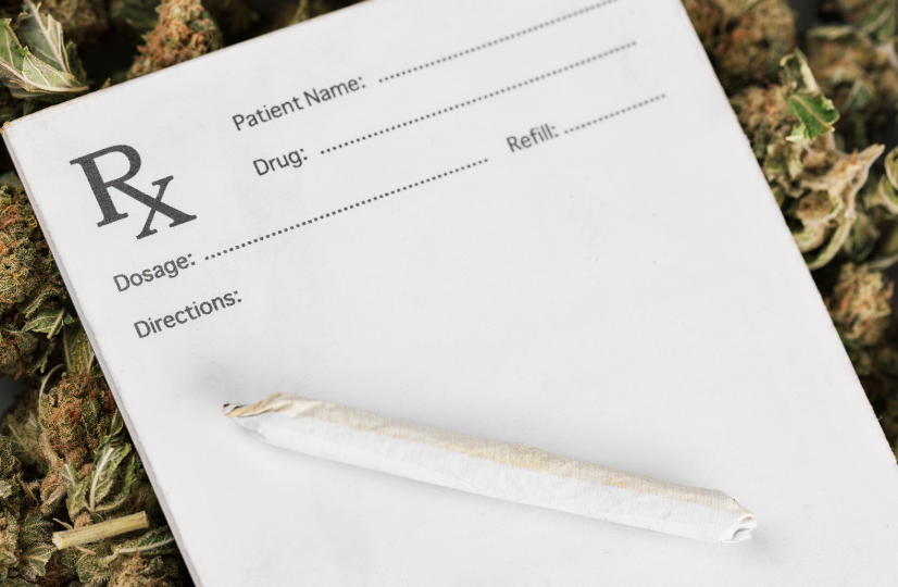 A prescription pad with a marijuana joint on top of it laying on a bed of cannabis flower