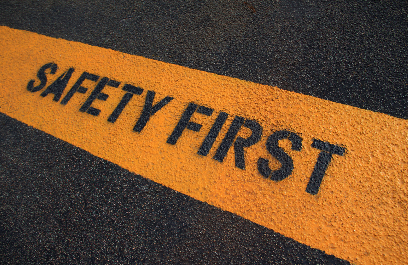 A yellow stripe on the road that says safety first