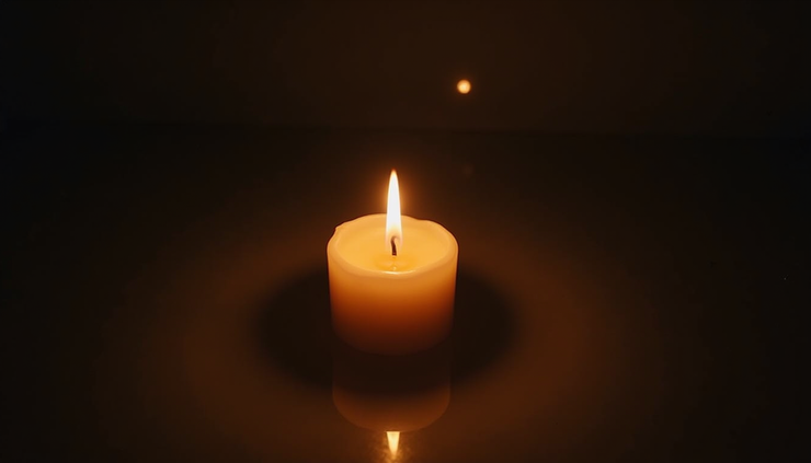 High angle view of a single candle burning softly in a dim room