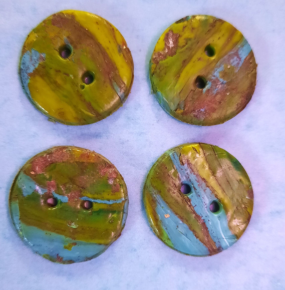Four round, multicolored buttons with earthy tones and two holes each, arranged in a square pattern on a light blue background.