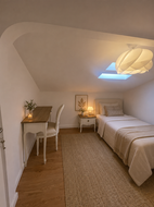 Modern attic bedroom interior with skylight in luxury Cascais duplex.