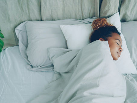 A young woman peacefully sleeping in white bed sets