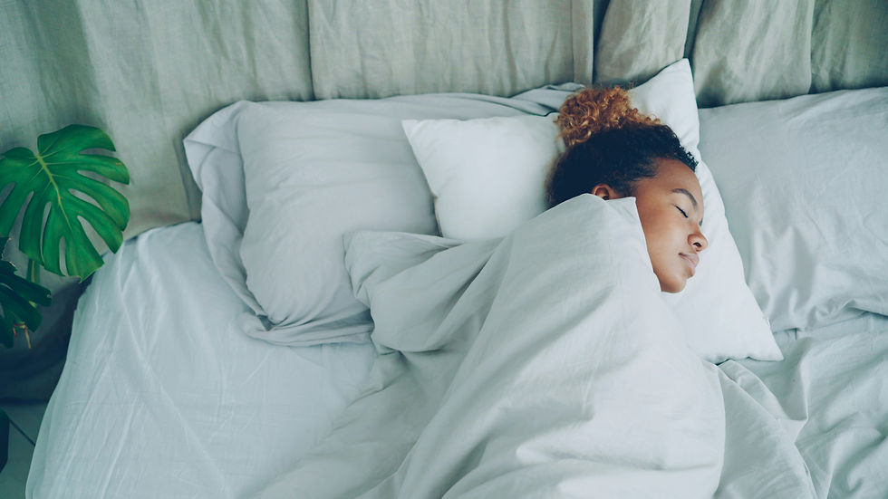 A young woman peacefully sleeping in white bed sheets