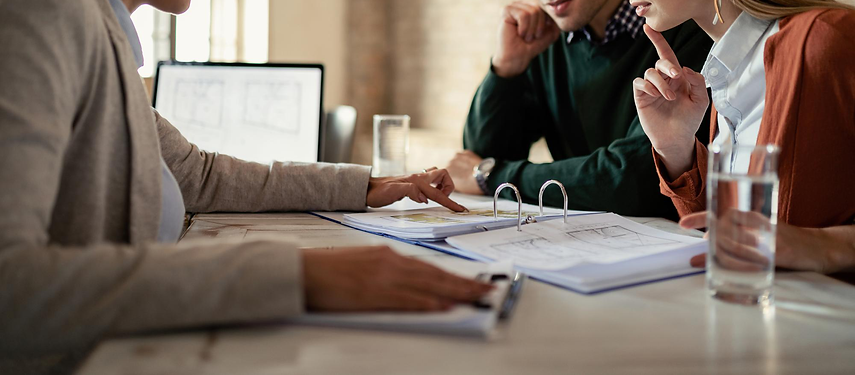 young-man-his-wife-examining-housing-plans-with-real-estate-agent-meeting-office.png