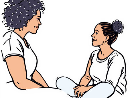 Two women sit cross-legged, facing each other and smiling. Both wear white tops. The background is plain white, conveying a calm mood.