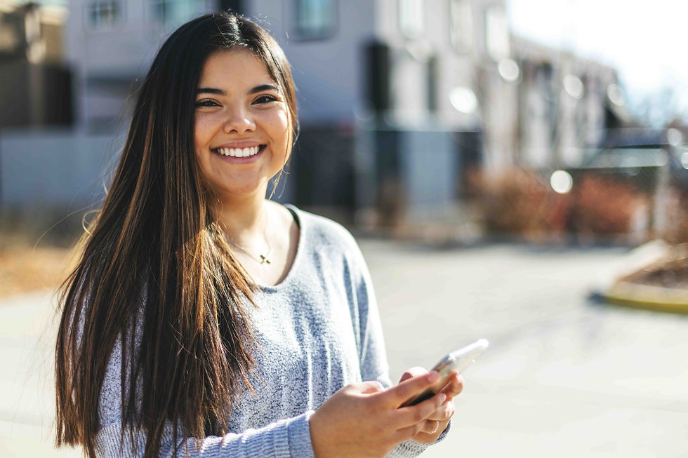 Young First Nations Woman outside business using smartphone
