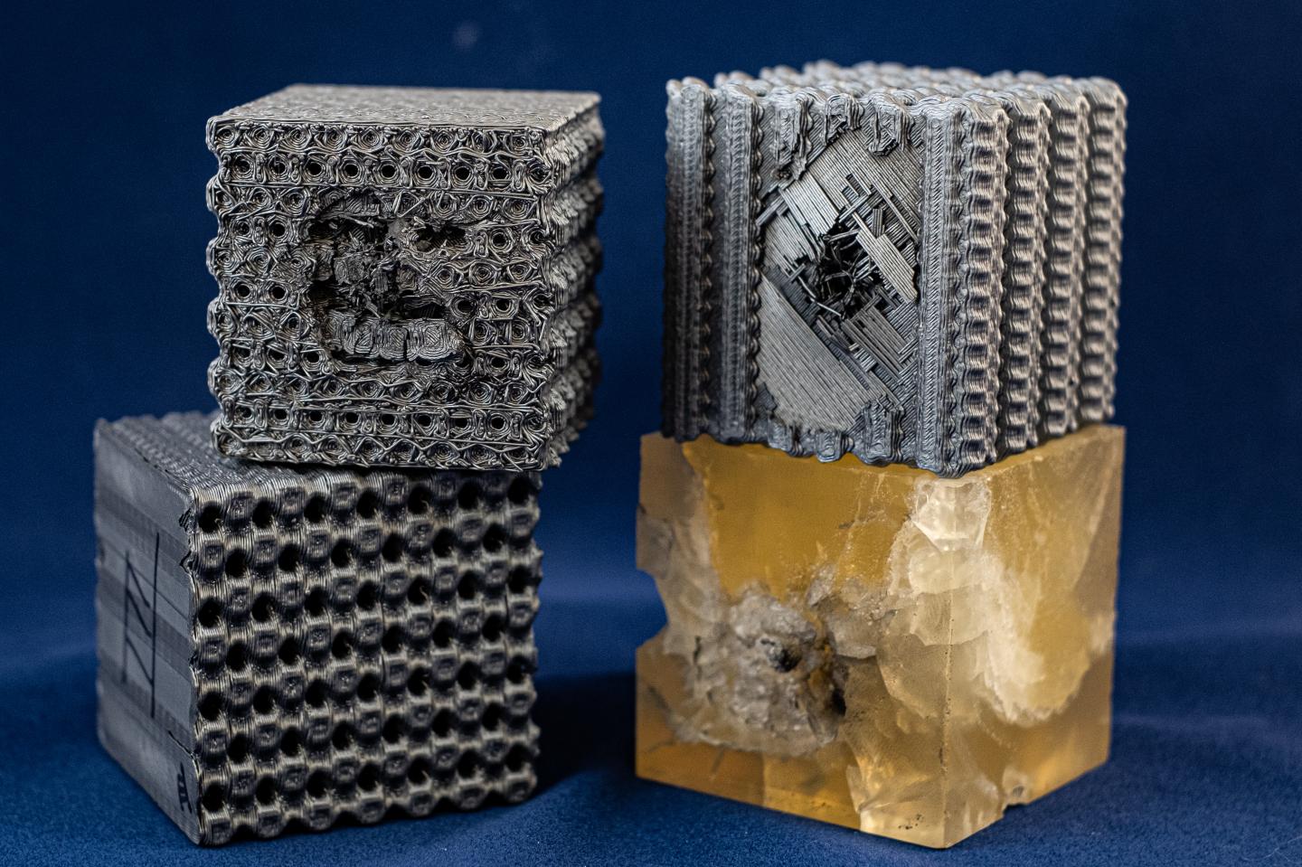Tubulane-like polymer structures created at Rice University were better able to handle the impact of a bullet than the polymer reference cube at bottom right. The bullet stopped in approximately the second layer of the tubulane structures, with no significant structural damage observed beyond that layer. Bullets fired at the same speed sent cracks through the entire reference cube. @ Jeff Fitlow/Rice University