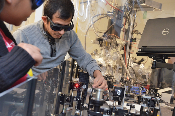 Graduate student Tika Kafle (facing camera) works on the time-resolved photoemission spectroscopy setup. @ Cody Howard/University of Kansas