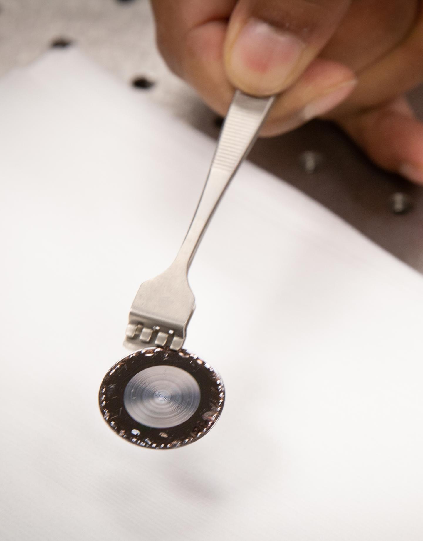 A flat lens developed by researchers at the University of Utah that is much thinner and lighter than a conventional lens that could produce lighter cameras for drones and night-vision cameras for soldiers. @ Dan Hixson/University of Utah College of Engineering