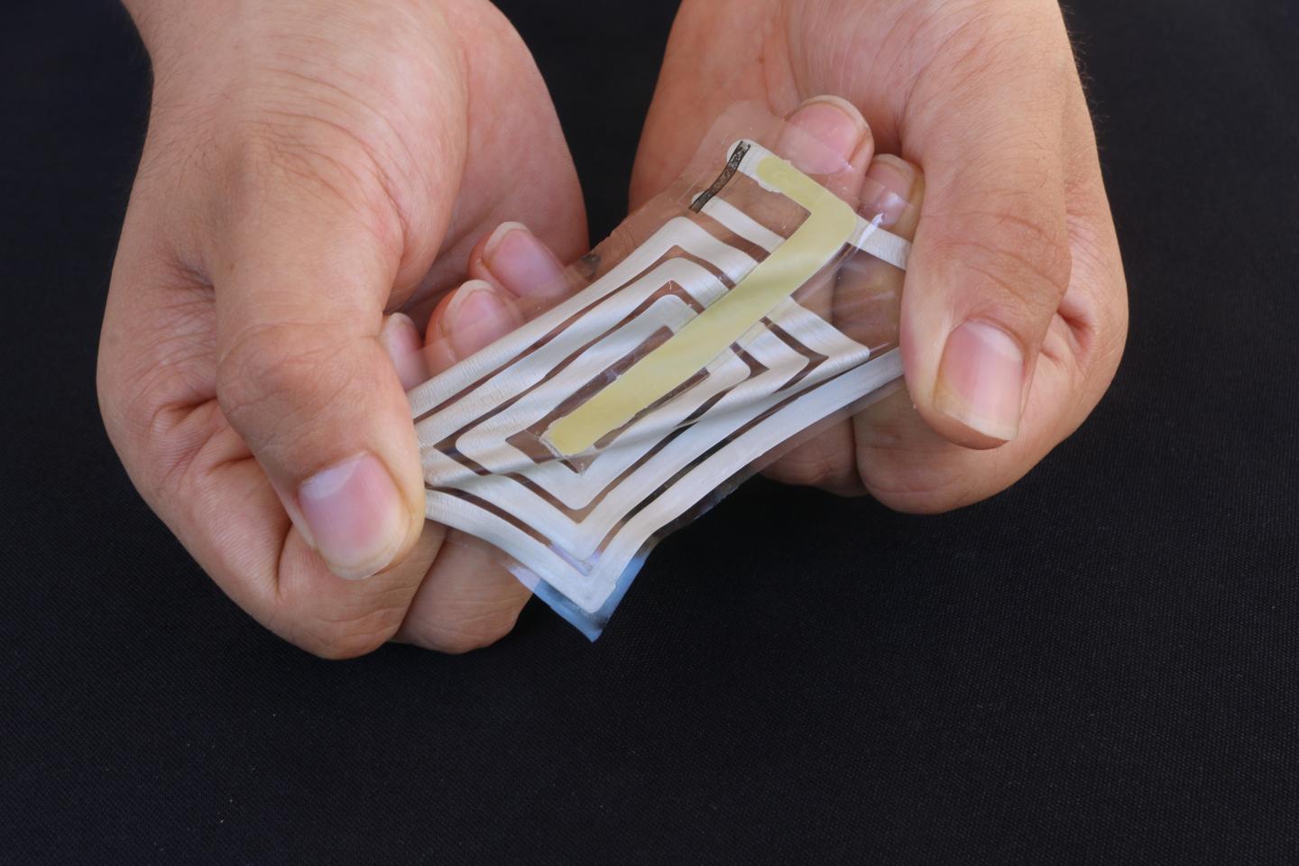 Using metallic ink, researchers screen-print an antenna and sensor onto a stretchable sticker designed to adhere to skin and track pulse and other health indicators, and beam these readings to a receiver on a person’s clothing. @ Bao Lab