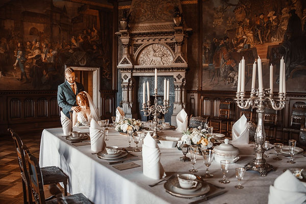 Brautpaar steht im stilvoll dekorierten Festsaal von Schloss Wernigerode