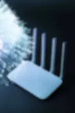 White Wi-Fi router with four antennas beside glowing fiber optic cables on a dark background, creating a tech-inspired atmosphere.