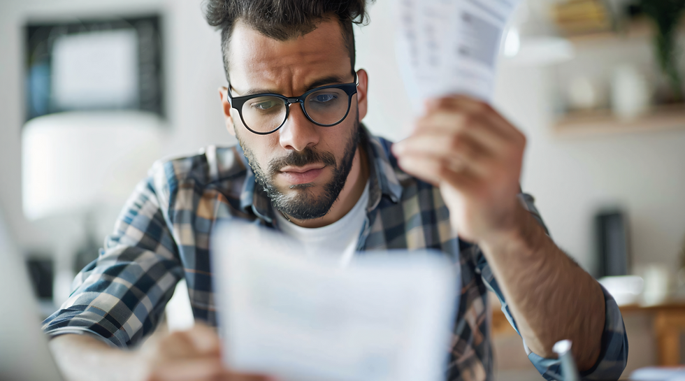 Jovem homem observando uma notea fiscal