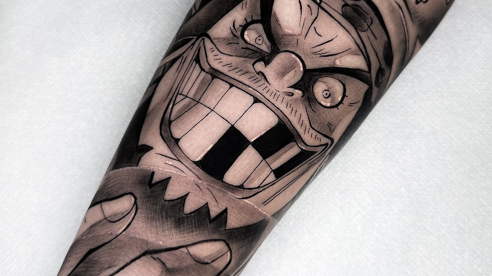 Vista laterale di un tatuaggio manga con colori intensi su spalla