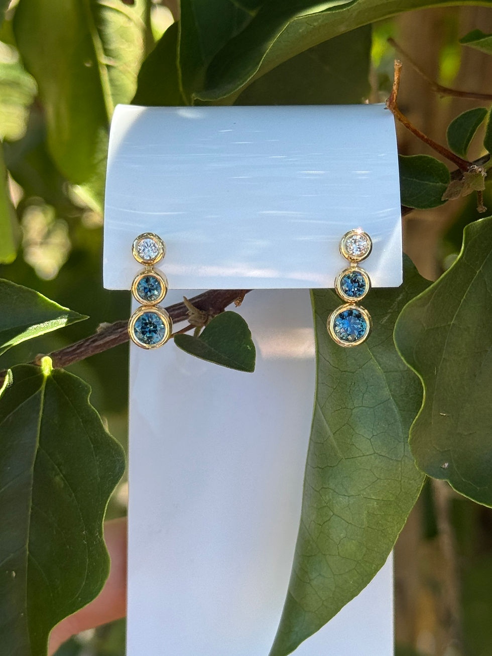 Thumbnail: 3 stone drop earrings featuring Australian Blue sapphires and Australian white zircons in 18k yellow gold